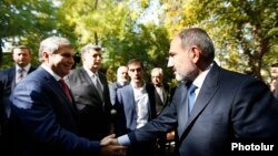 Armenia -- Prime Minister Nikol Pashinian (R) greets Aram Sarkisian at a memorial to the victims of the October 1999 deadly attack on the Armenian parliament, Yerevan, October 27, 2019.