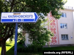 Расейскамоўны паказальнік вуліцы Каліноўскага на тле дома з арнамэнтам