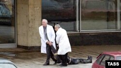 Врачи тащут тело погибшего в результате теракта человека. Москва, театр на Дубровке, 24 октября 2002 года.