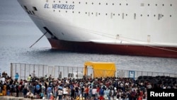 Грэцыя - Мігранты і ўцекачы з часовымі дакумэнтамі чакаць парома, які завязе іх у Атэны, у порце грэцкага вострава Кос. 14 жніўня 2015 году