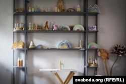 На паліцах — драўляныя вясёлкі, пірамідкі, матрошкі, маракасы