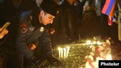Armenia - A police officer lays flowers at an unofficial memorial to the victims of the 2008 post-election violence in Yerevan, March 1, 2019.