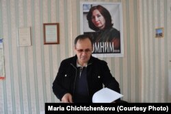 Оюб Титиев в грозненском офисе «Мемориала» в 2011 году. На стене – портрет Натальи Эстемировой. Фото: Мария Чищенкова.