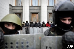 Байцы самаабароны Майдану каля Вярхоўнай Рады, якая прыняла рашэньне, што Віктар Януковіч самаўхіліўся ад выкананьня прэзыдэнцкіх паўнамоцтваў, 22 лютага 2014