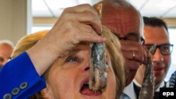 Ангела Меркель "Марк" балыкчылар трейлерында ясалган тозлы балыкны тәмләп карый