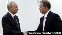 Повʼязаний з Кремлем колишній депутат Верховної Ради України Віктор Медведчук (праворуч) тисне руку президенту РФ Володимиру Путіну