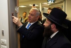 نتانیاهو در حال نصب یک مزوزا در دفتر مطبوعاتی دولت اسرائیل، ۲۰۱۲