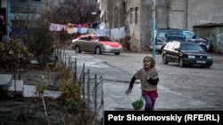 Девочка бежит во дворе многоэтажки в таджикском городе Хороге.