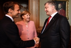 Зліва направо: п'ятий президент Франції Емманюель Макрон, федеральний канцлер Німеччини Ангела Меркель і президент України Петро Порошенко під час зустрічі в Аахені (Німеччина), 10 травня 2018 рік