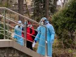 Медики супроводжують пацієнтку на огляд