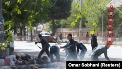 Афганские полицейские оказывают помощь раненным в результате взрыва журналистам. Кабул, апрель 2018 года