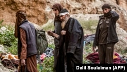 Күрд күчтөрүнө багынып берген «Ислам мамлекети» террордук тобунун мүчөлөрү. Сириянын Багхуз аймагы. 14-март, 2019-жыл.