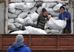 Жителям поселка помогают благотворительные организации. Разгрузка топливных брикетов от «Каритас-Мариуполь»