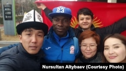 Кыргызстандын футбол боюнча улуттук курама командасынын коргоочусу Дэниел Тэго кыргызстандык күйөрмандар менен. Түштүк Кореяда билим алган студент Нурсултан Алтыбаев солдон оңго карай биринчи. 22-март, 2018-ж. Инчхон, Түштүк Корея.