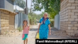 Azerbaijan -- Residents walk a village in Aghdam district located near the contact line with the Armenian troops – Aug2014
