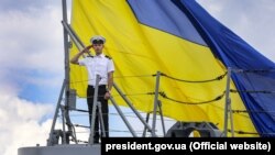 Матрос ВМСУ на тлі величезного прапора України на фрегаті «Гетьман Сагайдачний» під час багатонаціональних військових навчань «Сі Бриз-2018». Одеса, 16 липня 2018 року. Ілюстративне фото