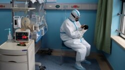 Медработник держит на руках новорожденного с COVID-19. Китай. Иллюстративное фото.