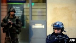 Поліцейський і солдат спільно патрулюють передмістя Парижа Сен-Дені, 18 листопада 2015 року