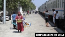 Söwdagärler Duşagyň otly menzilinde öýde bişirilen iýmit önümlerini ýolagçylara satýar. 
