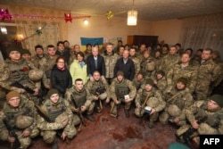 Президент Петро Порошенко і сенатори США Джон Маккейн, Ліндсі Ґрем та Еймі Клобучар разом із вояками України на командному пункті в районі населеного пункту Широкине під Маріуполем, 31 грудня 2016 року