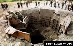 Журналісти стоять біля шахтної пускової установки, яку зруйновано в рамках відмови України від ядерної зброї, що було обумовлено Будапештським меморандумом, підписаним у 1994 році. Первомайськ, Миколаївська область, 29 вересня 1998 року