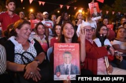 همسر نبیل قروی تصویری از او را در میان هوادارانش در دست دارد