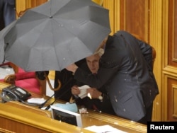 Спікер парламенту Володимир Литвин під парасолею, обкиданий яйцями, оголошує результати голосування за ратифікацію Угоди про подовження терміну перебування Чорноморського флоту Росії в Криму. 27 квітня 2010 року