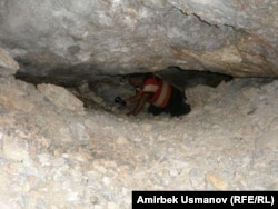 Мурдакы кенчи Тургун Муратов сымап казылчу эски кендин төрүндөгү тешиктердин бирине сойлоп кирип баратат. Сарт-Ыстаган. 20-июль ,2011