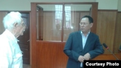 Жарылқап Қалыбай (оң жақта) өзінің үстінен шағымданушы ардагерлер өкілі Николай Жоговпен сот залында тұр. Алматы, 11 қыркүйек 2014 жыл.