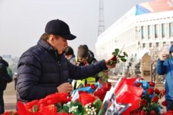 Активист Жанболат Мамай возлагает цветы к монументу Независимости в Алматы. 16 декабря 2019 года.