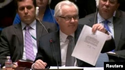 Посол Росії в ООН Віталій Чуркін на засіданні Ради безпеки ООН демонструє лист Віктора Януковича до керівника Росії Володимира Путіна з проханням використати війська для відновлення «законності та правопорядку в Україні». Нью-Йорк, 3 березня 2014 року