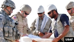 مهندسان آمریکایی و افغان در حال بررسی نقشه‌های یک پادگان ارتش افغانستان در سپتامبر ۲۰۰۸