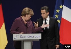 France -- President Nicolas Sarkozy and German Chancellor Angela Merkel talk to each other prior to holding a joint press conference following crisis talks with Greek Prime Minister in Cannes, 02Nov2011