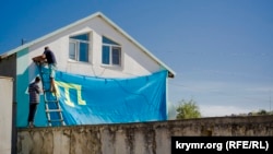 Qurban Bayramı arfesinde şahsiy evniñ üzerinde Qırımtatar bayrağı pekitile. Kefe, Bay Buğa qasabası, 13 sentâbr 2016 senesi. Alina Smutkonıñ çekken fotoresimi
