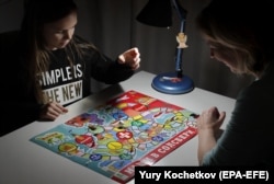 Дівчинка грає з матір’ю в настільну гру «Наші в Солсбері», Москва, січень 2019 року