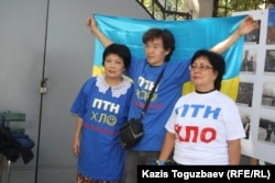 Гражданские активисты фотографируются на фоне флага Украины. Алматы, 30 августа 2014 года.