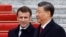 Chinese President Xi Jinping (right) welcomes French President Emmanuel Macron at the Great Hall of the People in Beijing on April 6.