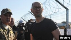 Прем’єр Арсеній Яценюк (праворуч) під час огляду зразків проекту «Стіна», які вже встановили поблизу прикордонного пункту на Харківщині, 15 жовтня 2014 року