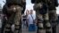 Люди розмовляють із білоруськими правоохоронцями поблизу місця, де протестувальник загинув 10 серпня під час мітингу після президентських виборів у Мінську, Білорусь, 11 серпня 2020 року.
