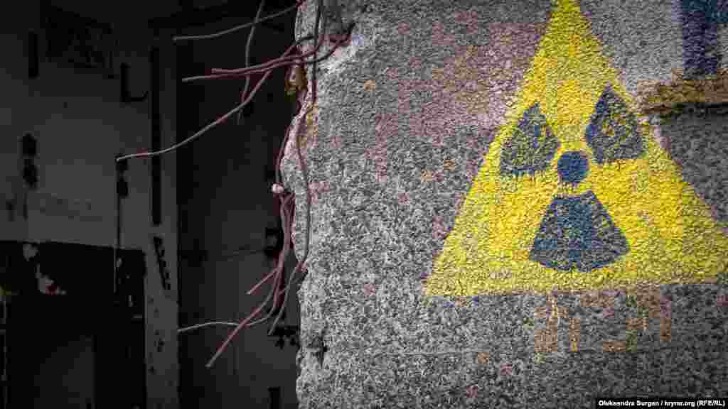 Stantsiya isini öyle de başlamağanını baqmadan, reaktornıñ bir divarında&nbsp;radiatsiya telükesi işareti bar