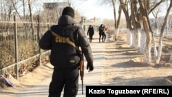 Боец специального отряда быстрого реагирования стоит на улице в городе Жанаозен  19 декабря 2011 года. Иллюстративное фото.