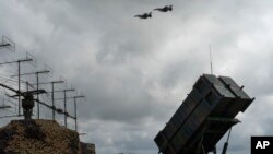 Винищувачі F-16 ЗСУ пролетіють над ЗРК «Патріот» у невідомому місці в Україні. 2024 рік