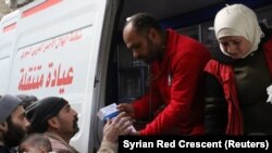 Эл аралык Кызыл чырым уюмунун ыктыярчылары Гутадагы карапайым элге дары-дармек таратып жатат. 5-март, 2018-жыл.  