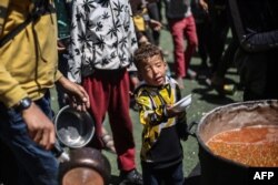 توزیع غذا در یک اردوگاه پناهندگان در مرکز نوار غزه، ۳۰ فروردین