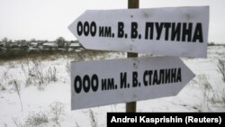 Росія. Вказівник в Алтайському краї в селі Горновка, який вказує, як дібратися до Товариства з обмеженою відповідальністю імені В.В. Путіна. А інший вказівник вказує напрямок до ТОВ імені Й.В. Сталіна. Село Горновка