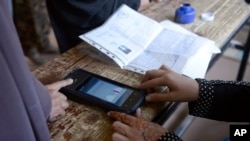 A woman's finger is scanned before casting her vote during parliamentary elections in Kandahar on October 27.