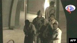 در تصاويری که برخی از شبکه های تلويزيونی از لحظه خروج اين افراد به همراه سربازان آمريکايی پخش کرده اند، آنها با چشمان بسته و دستبند ديده می شوند.