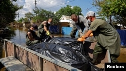 Комунальники і волонтери збирають тіла загиблих внаслідок потопу в окупованій Голій Пристані на Херсонщині, 16 червня 2023 року
