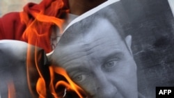 معترضان در ترکیه پوستر بشار اسد، رییس جمهور سوریه، را در اعتراض به کشتار مخالفان سوری به آتش می کشند.