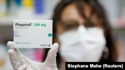 A pharmacist displays a box of Plaquenil